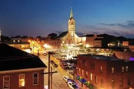Historic downtown Washington, Missouri buildings lit at dusk with church steeple